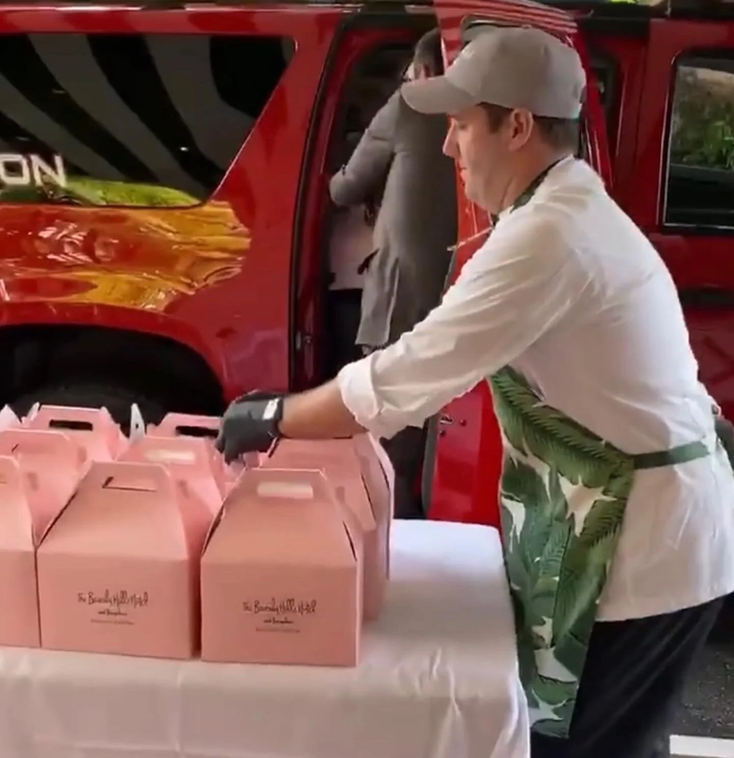 Beverly Hills Hotel chef arranging donation boxes near a fire truck